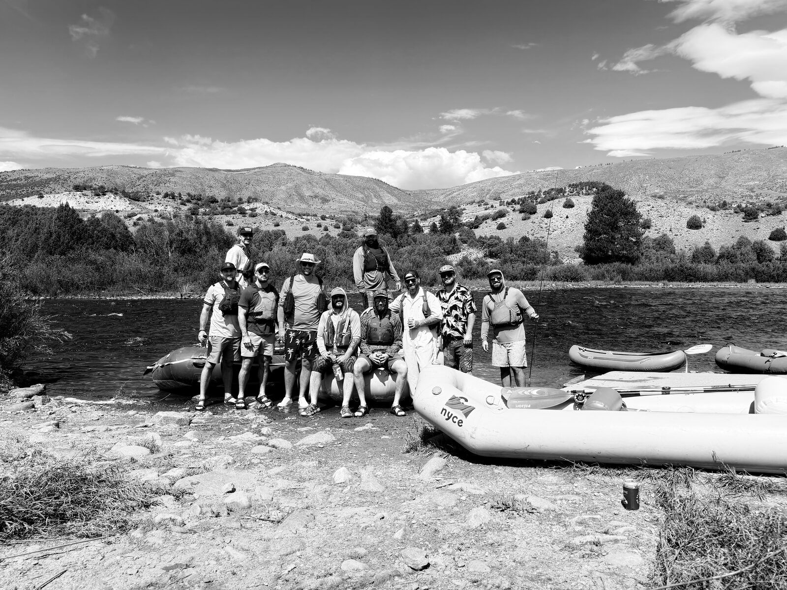 Golden League friends gathered with their rafts beside a river in the mountains